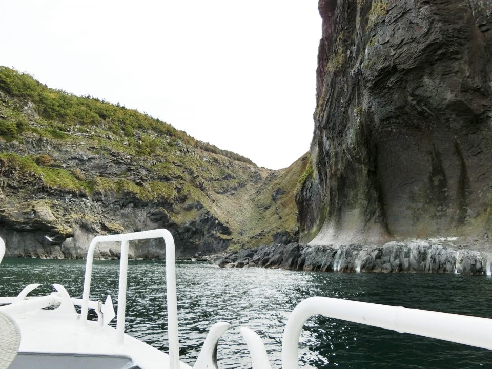 断崖の近くを航行するクルーザー