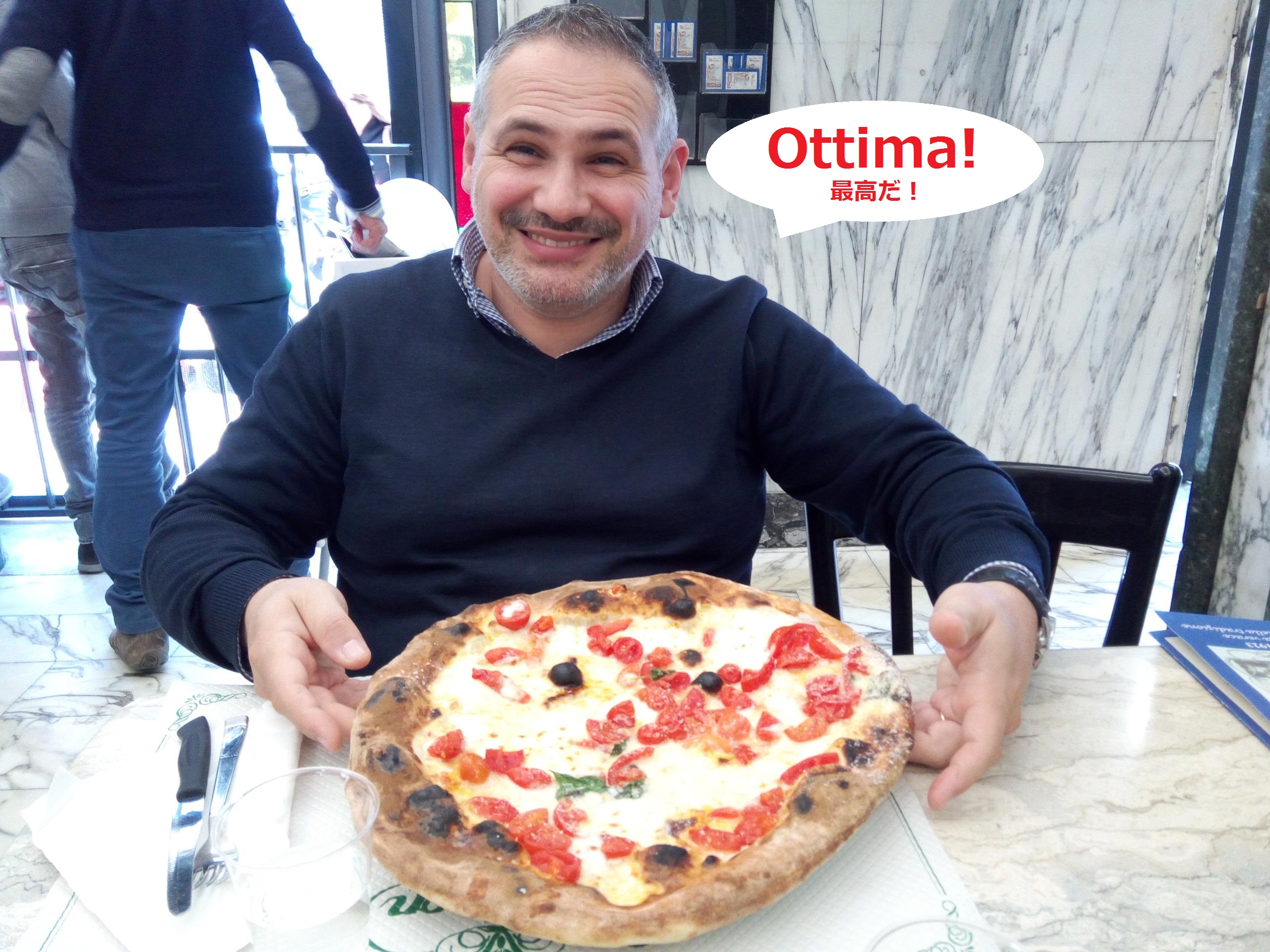 ナポリのピッツェリア「トリアノン」でピザをもつイタリア人